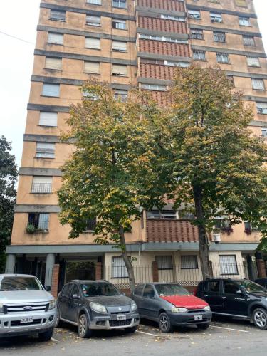 eine Gruppe von Autos, die vor einem hohen Gebäude geparkt werden in der Unterkunft Tinku-Huasi Apart in San Salvador de Jujuy