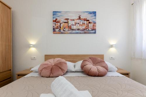 a bedroom with a bed with two pillows on it at Apartment Vuletin in Kaštela