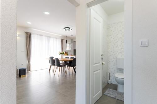 Ein weißes Zimmer mit einem Tisch und einem Esszimmer. in der Unterkunft Apartment Vuletin in Kaštela
