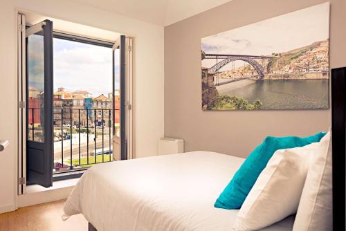 1 dormitorio con ventana grande con vistas a un puente en oldcity design apartments, en Oporto