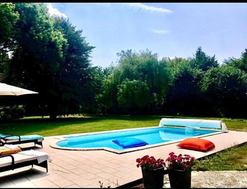 - une piscine au milieu d'une cour dans l'établissement Chaumière de charme cosy, à Saint-Éloi-de-Fourques