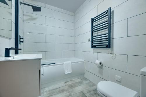 La salle de bains est pourvue d'une baignoire, de toilettes et d'un lavabo. dans l'établissement Hudson's Haven Apartments by Week2Week, à Newcastle upon Tyne