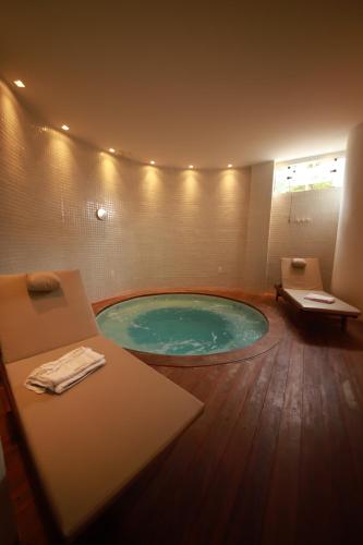 a bathroom with a jacuzzi tub in the floor at Pousada Rangai in Maragogi