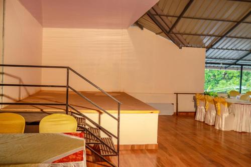 a room with a staircase and chairs in it at Belljem Homes -your own private resort -3 BHK FF in Trichūr
