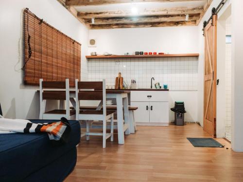 a living room with a table and a kitchen at Awana Farmhouse Dieng in Dieng