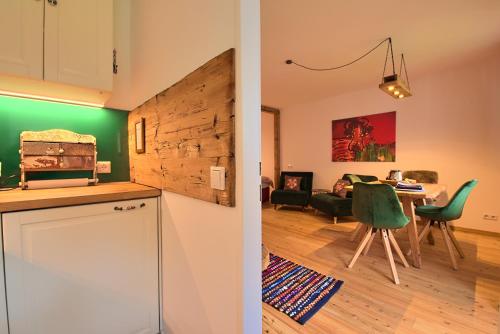 een keuken en een woonkamer met een tafel bij Alpen Apartment Werfenweng - Ruhe - Pool in Werfenweng