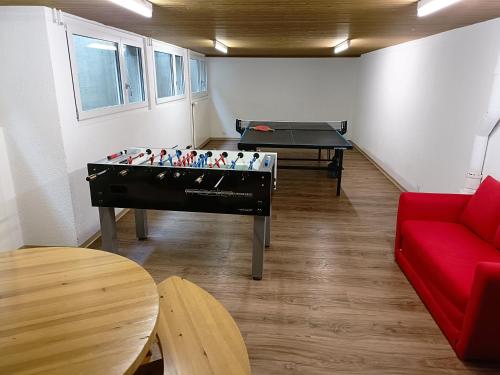 a living room with a pool table and a red couch at Ferien in der Region Lenzerheide in Lenz