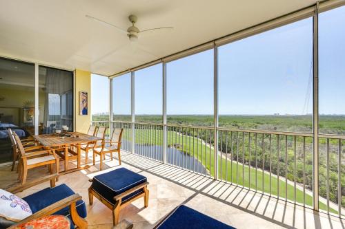 a balcony with a table and chairs and large windows at Estero Resort Condo with 2 Pools and Tennis Center! in Estero