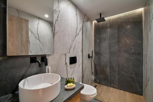 een badkamer met een wastafel, een douche en een toilet bij PORTA SQUERO Premium Suites in Rethimnon