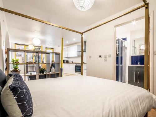 1 dormitorio con 1 cama blanca grande y cocina en Pass the Keys Stylish and central character flat with courtyard en Exeter