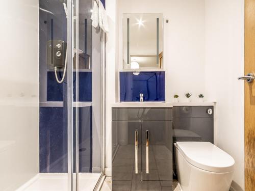a bathroom with a toilet and a glass shower at Pass the Keys Stylish and central character flat with courtyard in Exeter
