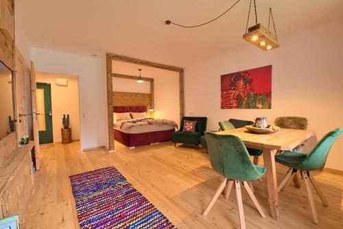 - un salon avec une table, des chaises et un lit dans l'établissement Alpen Apartment Werfenweng - Ruhe - Pool, à Werfenweng