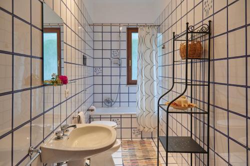 a bathroom with a white sink and a tub at Villa Failla in Castelbuono