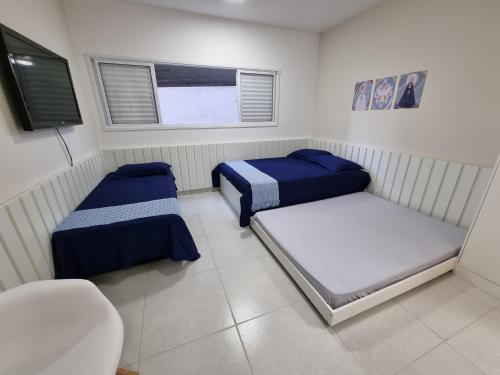 ein Schlafzimmer mit zwei Betten und einem Fenster in der Unterkunft Morada da Fé II à 300 m da canção nova Cond. da Fé in Cachoeira Paulista