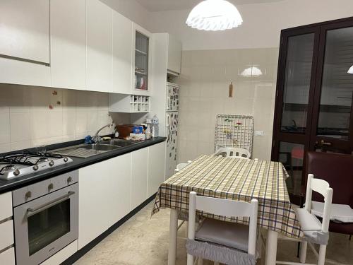 Una cocina con una mesa, una estufa y un fregadero. en Casa A&G, en Marsala