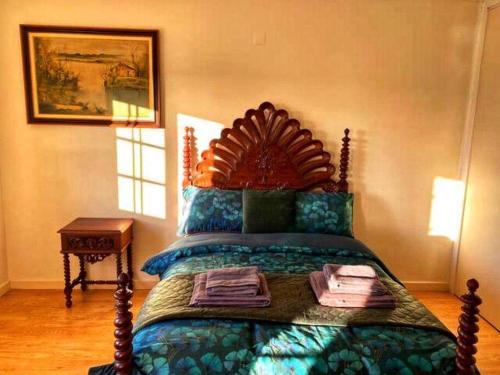 1 dormitorio con 1 cama con cabecero de madera en Oceans house - Pool, Sauna, 22 Sleeps, 7m to beach en Carcavelos