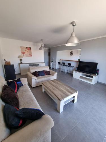 a living room with two couches and a coffee table at Casa agapanthe in Estreito da Calheta