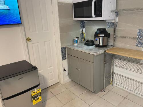 a small kitchen with a microwave and a refrigerator at Best Value inside City Miami, Near Airport, Beach, Center & Metro in Miami