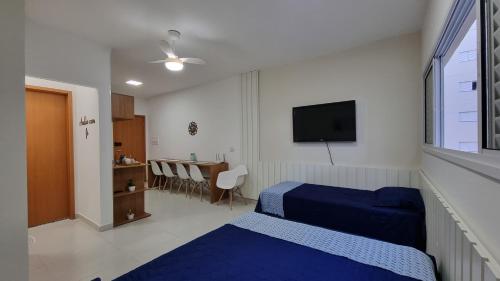 ein Hotelzimmer mit zwei Betten und einem Fernseher in der Unterkunft Morada da Fé II à 300 m da canção nova Cond. da Fé in Cachoeira Paulista