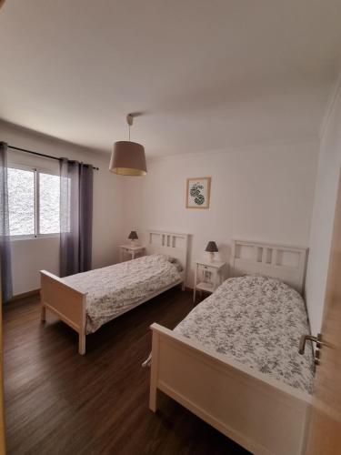 a bedroom with two beds and two tables at Casa agapanthe in Estreito da Calheta