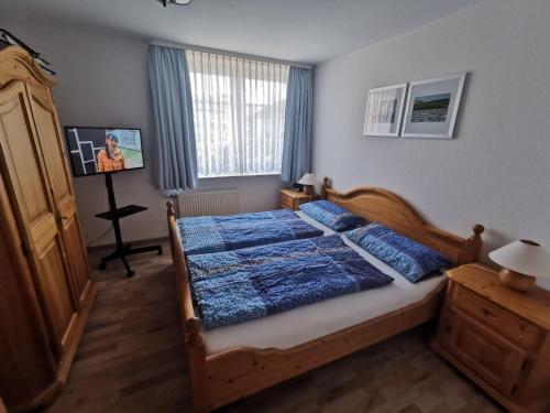 um quarto com uma cama com um edredão azul em Yachthus em Carolinensiel