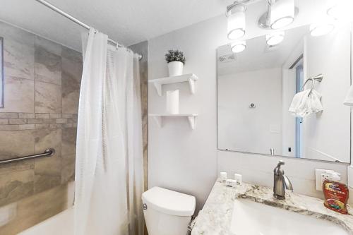 a bathroom with a toilet and a shower and a sink at First Street South Serenity in Jacksonville Beach