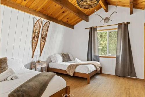 1 Schlafzimmer mit 2 Betten und einem Fenster in der Unterkunft Le Chalet of Arrowbear Lake in Running Springs