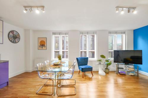 a living room with a table and chairs and a tv at Mulberry Flat 5 - One bedroom 3rd floor by City Living London in London