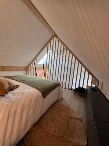 une chambre avec un lit et une grande fenêtre dans l'établissement Gîtes de la Chapelle, à Gigny-sur-Saône