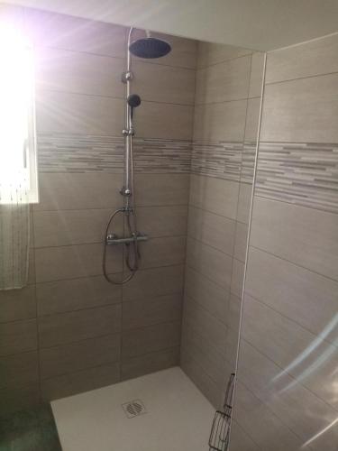 une salle de bain avec une douche avec une porte vitrée dans l'établissement Gîte le Jaya, à Saint-Georges-de-Luzençon