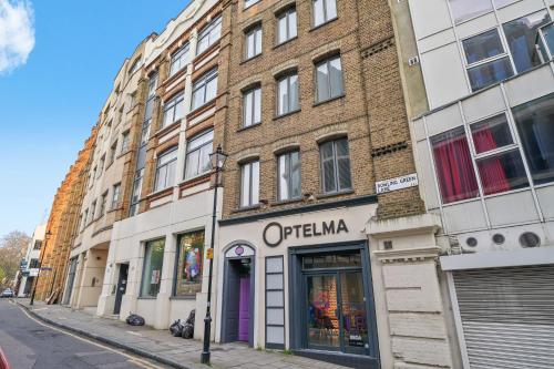 a building on a city street with a store at Mulberry Flat 5 - One bedroom 3rd floor by City Living London in London