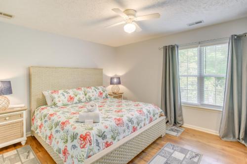 a bedroom with a bed and a window at Charming Oak Island Home 1 Mi to Beach! in Oak Island