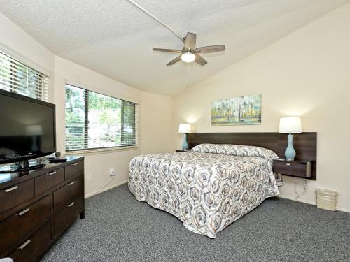 a bedroom with a bed and a flat screen tv at Lakefront Bungalow With Pool & Hot Tub #4 in Lakeway