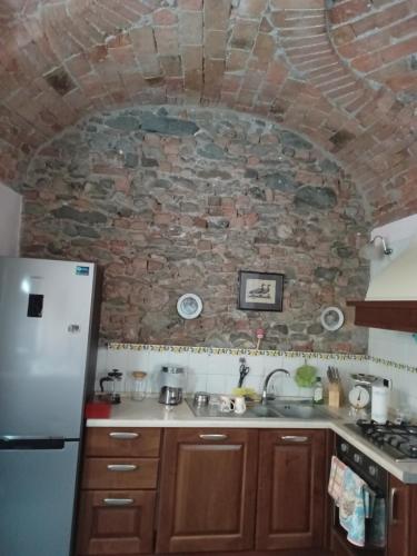 a kitchen with a stone wall and a refrigerator at Antiche Mura in Avigliana