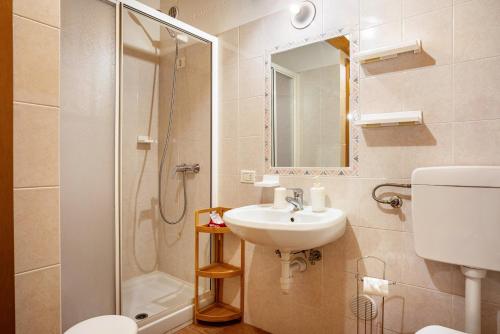 y baño con aseo, lavabo y ducha. en Aparthotel Alperose Strembo, en Strembo