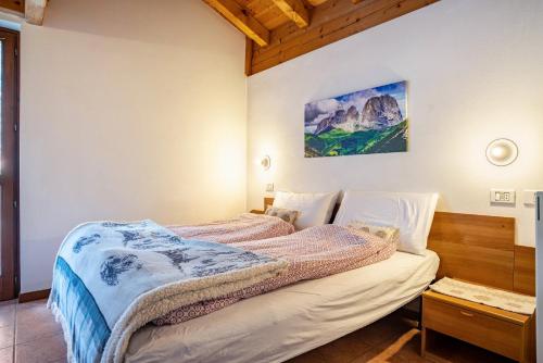 1 dormitorio con 1 cama con una pintura en la pared en Aparthotel Alperose Strembo, en Strembo