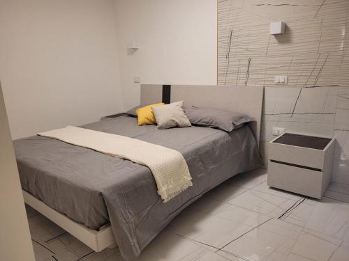 a bedroom with a bed with a yellow pillow at La finestra sul corso in Ortona