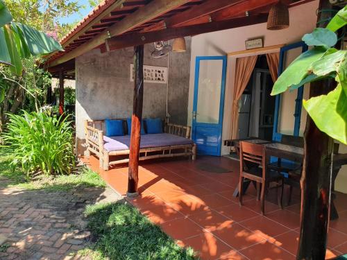 a porch of a house with a bed and a table at An Bang Hideaway in Hoi An