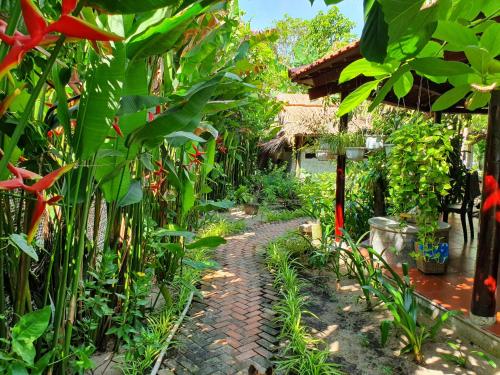 a garden with green plants and a brick path at An Bang Hideaway in Hoi An