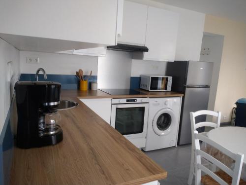 une cuisine avec un comptoir et un lave-linge/sèche-linge dans l'établissement T2 charmant avec terrasse 650m de la mer Pornichet, à Pornichet