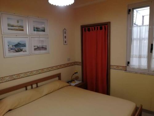 1 dormitorio con cama y cortina roja en Appartamento Policastro - Vista mare, 