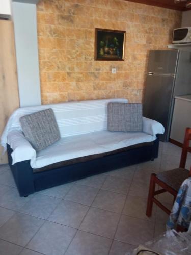 a couch sitting in a room with a brick wall at Annas apartment in Sikia