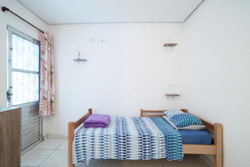 1 dormitorio con cama y ventana en Aconchego Azul Suítes Vila Mariana, en São Paulo