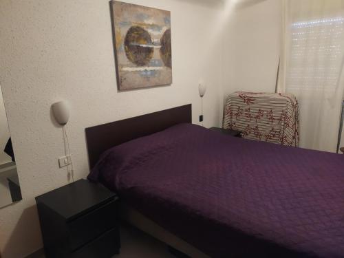 a bedroom with a purple bed and a window at El Médano PlayaMar in El Médano