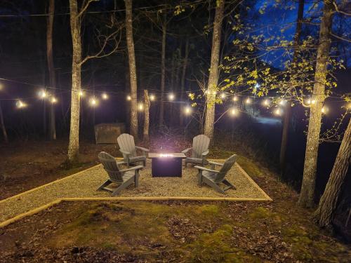 dos sillas y una mesa en un bosque por la noche en Bears Hideaway, en Pigeon Forge