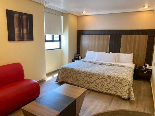 ein Hotelzimmer mit einem Bett und einem roten Stuhl in der Unterkunft HOTEL M ELITE ROJO in Mexiko-Stadt