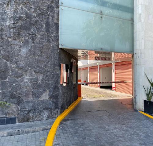 ein Gebäude mit einer Steinmauer und einer gelben Linie in der Unterkunft HOTEL M ELITE ROJO in Mexiko-Stadt