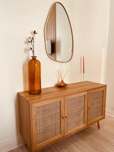 a wooden dresser with a mirror on top of it at Studio récemment rénové proche gare et ville in Nice