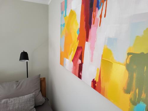 a painting on a wall next to a bed at Ferienwohnung Bad Doberan - mit Garten und Terrasse - 2023 neu renoviert in Bad Doberan