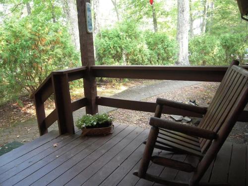 a wooden porch with a chair and a potted plant at Bears Hideaway in Pigeon Forge